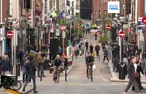 Gente en bicicleta por una concurrida calle de Dublín, Irlanda. 