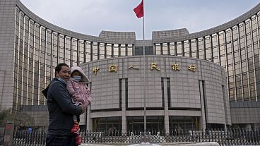 A man carries a child in front of China's central bank in Beijing