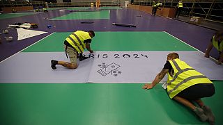 Des ouvriers préparent le terrain de boccia lors d'une visite de l'Arena Paris Sud en vue des Jeux Paralympiques, lundi 19 août 2024 à Paris. 