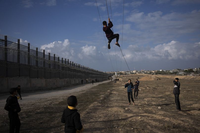 ملف - فلسطينيون نزحوا بسبب القصف الإسرائيلي لشمال قطاع غزة يلعبون بجوار الحدود مع مصر، في رفح، على طول ممر فيلادلفيا، جنوب غزة، الأحد 14 يناير 2024. (AP Photo/Fatima Shbair, F