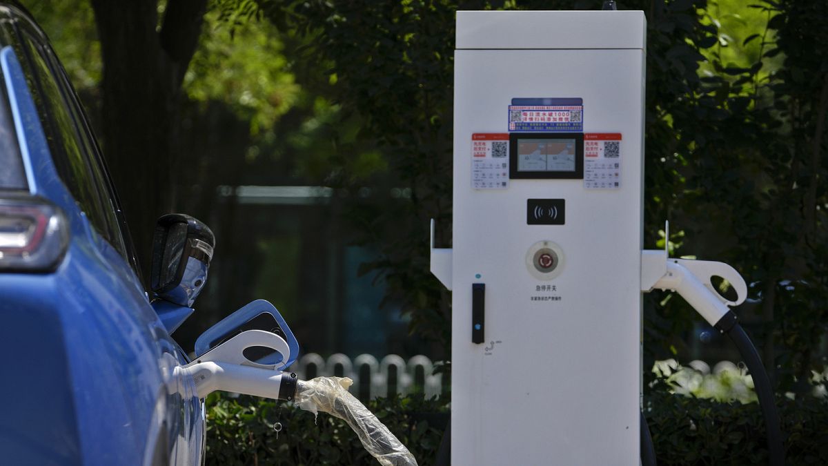 Um veículo elétrico chinês carrega numa estação de carregamento de veículos eléctricos em Pequim, segunda-feira, 24 de junho de 2024.