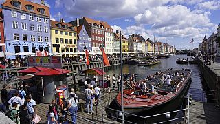 FILE - Tourists in the harbour in Copenhagen, Denmark, during a hot summer day with temperatures over 30 degrees Celsius, Friday, June 18, 2021.