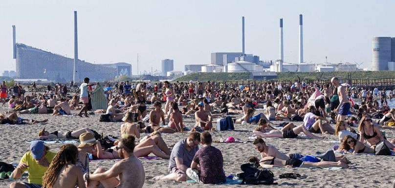 People move to the beach in Copenhagen, Denmark, during a hot summer day with temperatures over 30 degrees Celsius, Friday, June 18, 2021. 