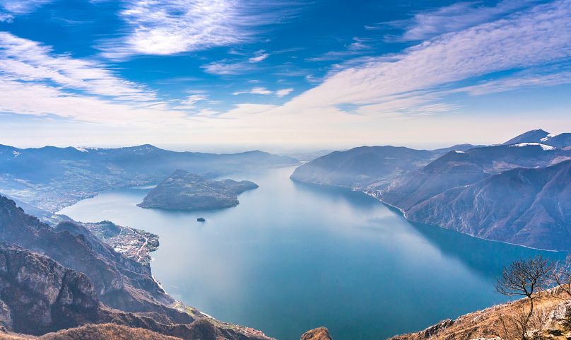 In the middle of the waterbody is Monte Isola, an island that rises up steeply, its slopes thick with vegetation. 