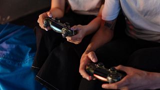 Personas sosteniendo los mandos de una consola de videojuegos