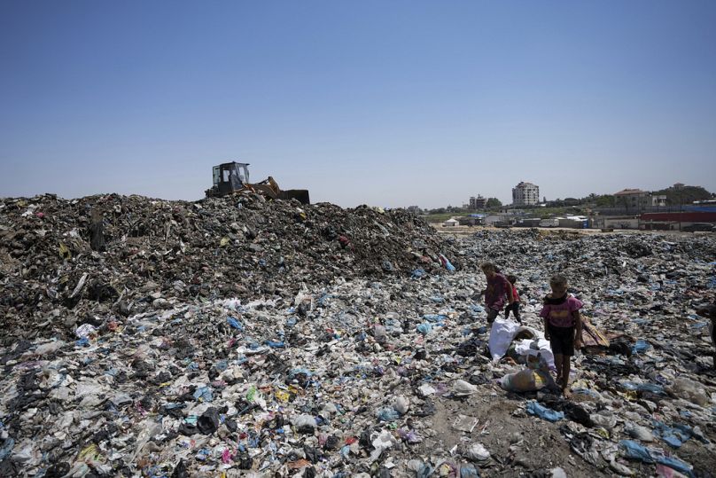 ملف - فلسطينيون يفرزون القمامة في مكب نفايات في مخيم النصيرات للاجئين بقطاع غزة، الخميس 20 يونيو 2024. تسابق السلطات الصحية ووكالات الإغاثة الزمن لتجنب تفشي شلل الأطفال في قطا