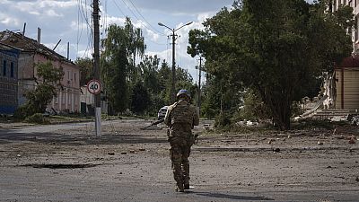 A Ukrainian soldier walks past at a city centre in Sudzha, Kursk region, Russia, Friday, Aug. 16, 2024. 