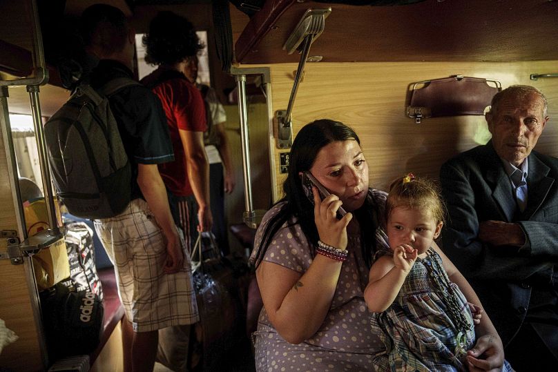 Une famille est assise dans un train d'évacuation à Pokrovsk, dans la région de Donetsk, en Ukraine, le lundi 19 août 2024.