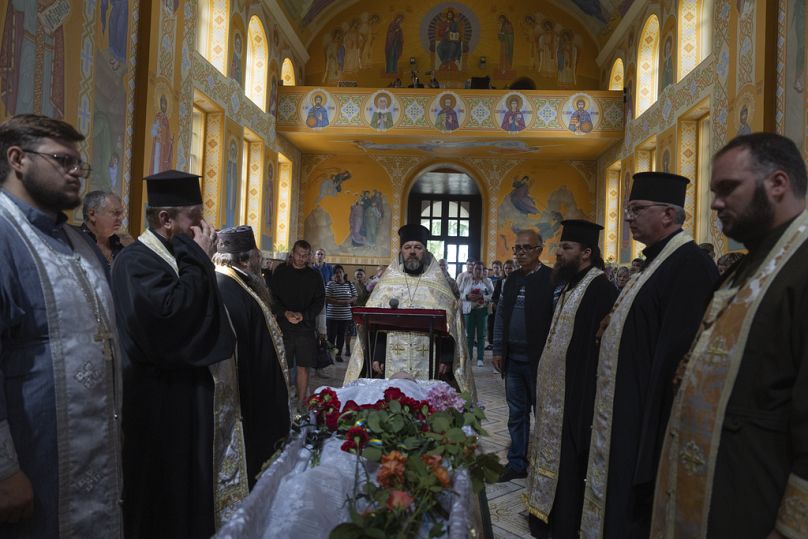 Orthodox priests conduct the funeral service for fellow villager who was killed in a battle with the Russian troops close to Kyiv, Ukraine, Thursday, June 20, 2024