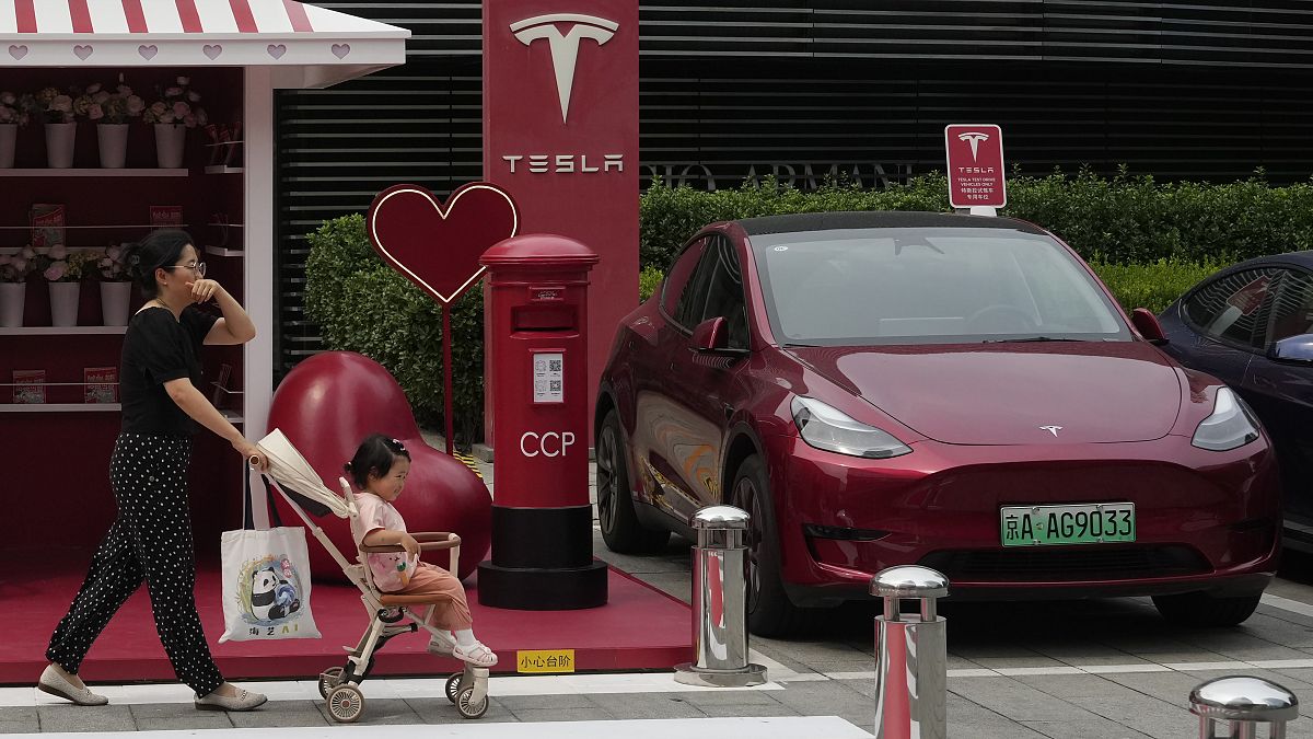 ARCHIVO: Vehículo Tesla rojo en una estación de carga en Pekín, el 24 de julio de 2024.