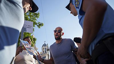 Social media influencer Andrew Tate talks to gendarmes during a protest near the French Embassy in Bucharest, Romania, Sunday, July 28, 2024