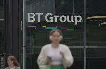 A woman walks in front of the BT headquarters, in London, Thursday, May 18, 2023. 