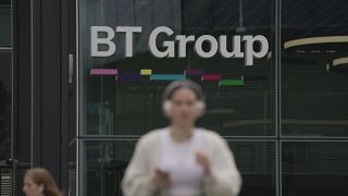 A woman walks in front of the BT headquarters, in London, Thursday, May 18, 2023. 