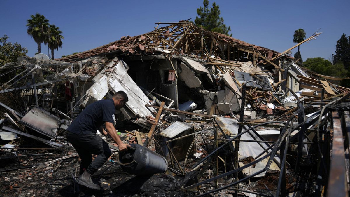 Un uomo vicino a una casa distrutta dopo il lancio di razzi a Katzrin, nelle Alture del Golan annesse a Israele, 21 agosto 2024