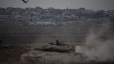 Des soldats israéliens se déplacent sur le toit d'un char près de la frontière entre Israël et Gaza, vu du sud d'Israël, le mercredi 21 août 2024.