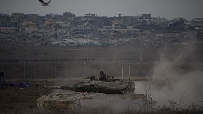 Des soldats israéliens se déplacent sur le toit d'un char près de la frontière entre Israël et Gaza, vu du sud d'Israël, le mercredi 21 août 2024.