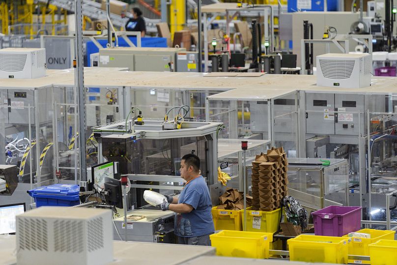 An employee makes custom boxes with a cardboard machine manually at the Amazon OXR1 fulfillment centre in California, August 21, 2024