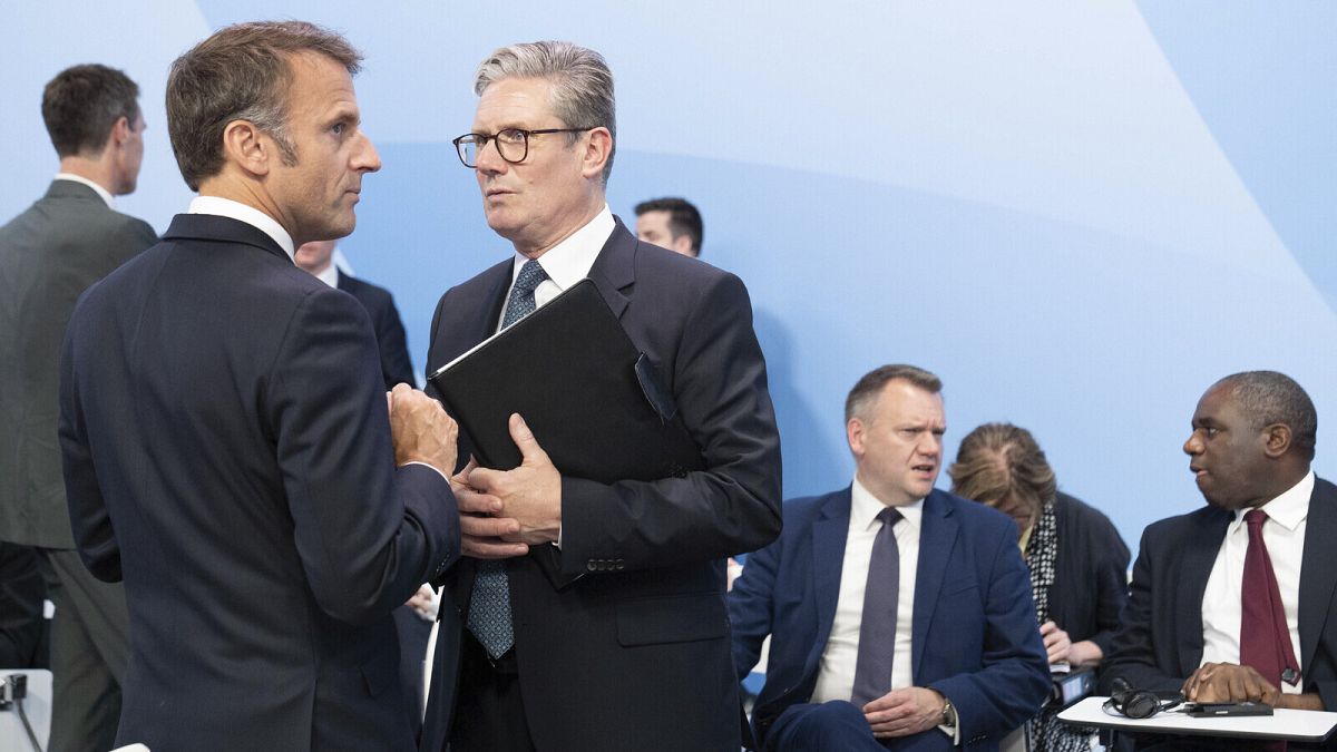 French President Emmanuel Macron, left, speaks with British Prime Minister Keir Starmer during the closing plenary at the European Political Community summit, Thursday July 18