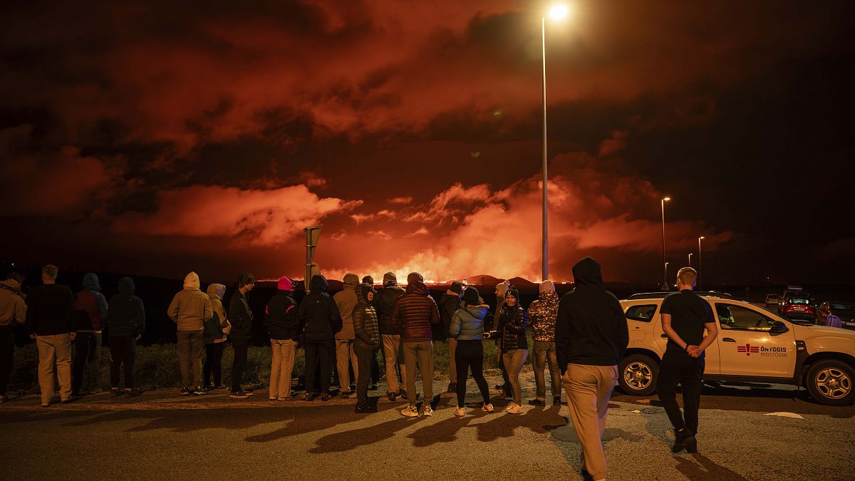 Turistas y visitantes intentan ver la erupción desde la distancia desde la intersección entre Reykjanesbraut y la carretera a Grindavik, el jueves 22 de agosto