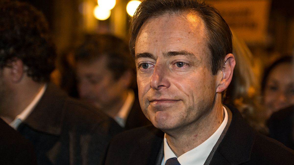 Líder do partido NVA, Bart De Wever, sorri enquanto caminha com membros do partido NVA em direção à Câmara Municipal de Antuérpia, na Bélgica; domingo, 14 de outubro de 2012