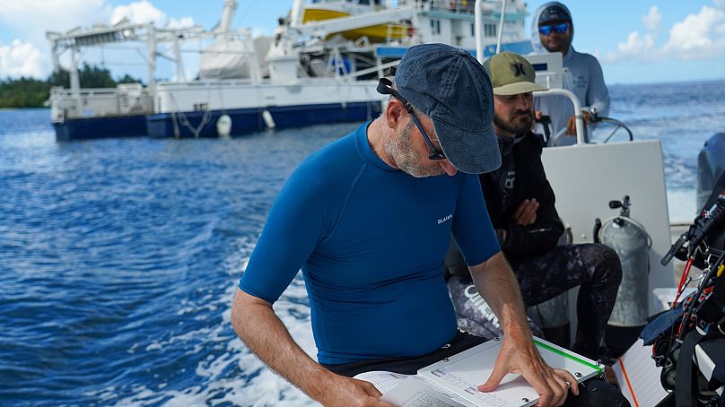 Quim preparing documents before coral reef survey near Tunnung Island, New Ireland Province, Papua New Guinea. 