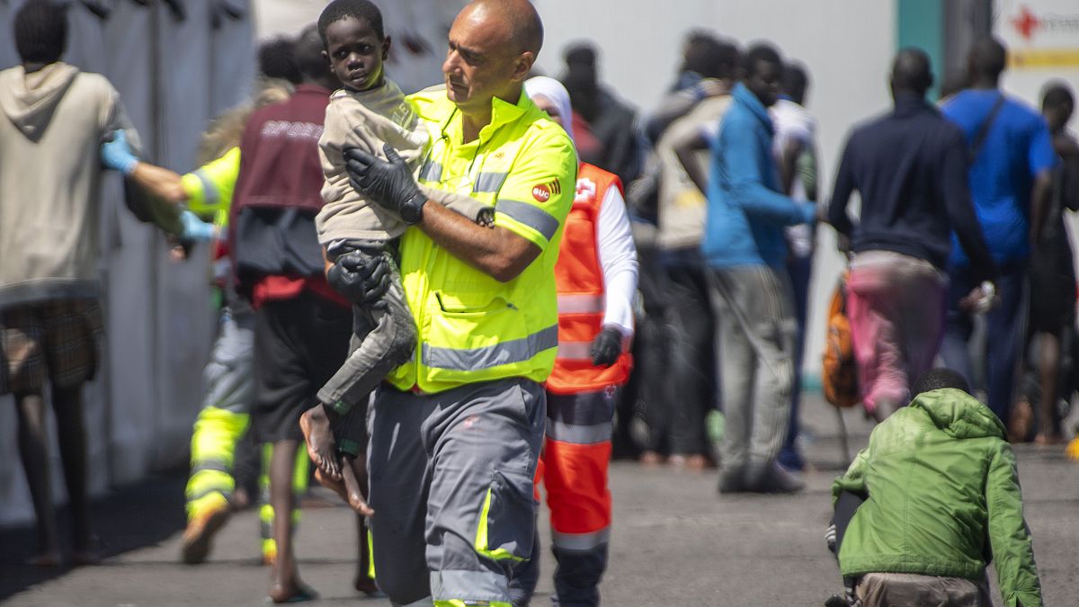 Un bambino viene assistito da un membro della squadra di emergenza dopo essere stato salvato da una barca nel porto di La Restinga, sull'isola canaria di El Hierro