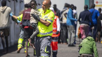 Un niño atendido por un miembro del equipo de emergencia después de ser rescatado de un barco en el puerto de La Restinga en la isla canaria de El Hierro.