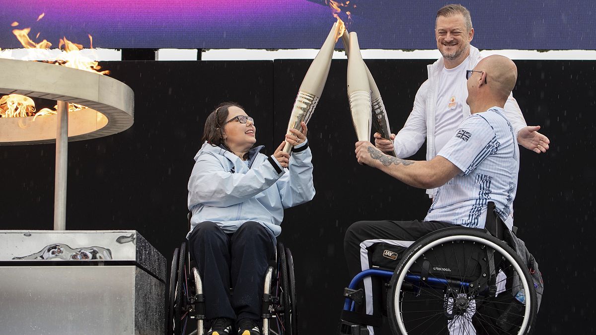 Paralympioniken Helene Raynsford und Gregor Ewan entzünden am Samstag, 24. August 2024, die paralympische Flamme in Stoke Mandeville in England.