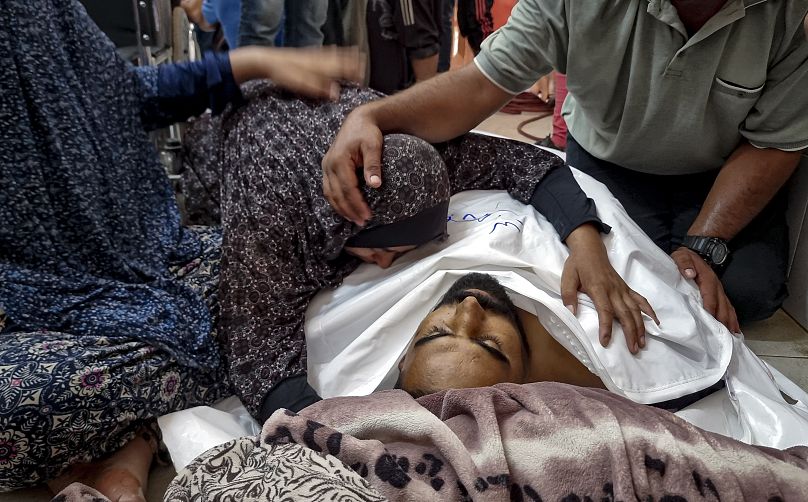 Palestinians mourn a relative killed in the Israeli bombardment of the Gaza Strip, at a hospital in Khan Younis, Saturday, Aug. 24, 2024.