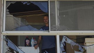 A man looks at a damaged window of a house following an attack from Lebanon, in Acre, north Israel, Sunday, Aug. 25, 2024