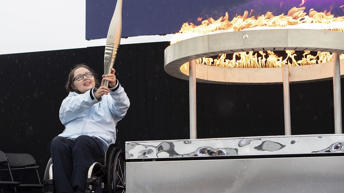 L'athlète paralympique britannique Helene Raynsford tient la torche paralympique lors de la cérémonie d'allumage de la flamme à Stoke Mandeville, le 24 août 2024.