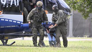 The alleged perpetrator of the knife attack in Solingen is escorted from a helicopter in Karlsruhe, Germany, Sunday, Aug. 25, 2024.