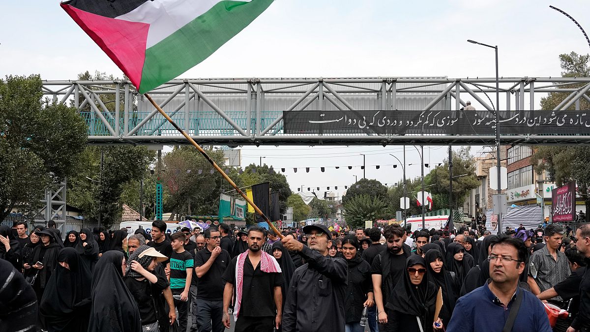 ناعي يلوّح بالعلم الفلسطيني خلال مراسم الأربعين التي تحيي نهاية فترة الحداد الممتدة 40 يومًا بعد مقتل الإمام حسين، حفيد النبي محمد، جنوب طهران، إيران، يوم الأحد 25 أغسطس 2024