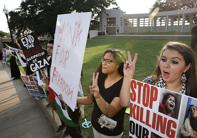 أنصار فلسطين ماري البنا، على اليمين، وروزالينا ليسيريو، الثانية من اليمين، يرفعون علامة النصر خلال احتجاج في ساحة ديلي، يوم الأحد، 3 أغسطس 2014، في دالاس