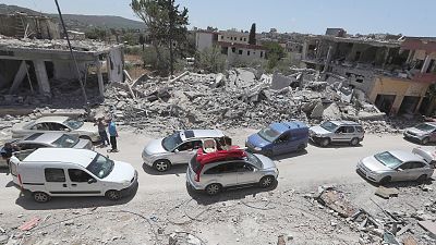 FILE: People inspect their destroyed houses that were hit by an Israeli airstrike, in Aita al-Shaab village, south Lebanon, 29 June 2024