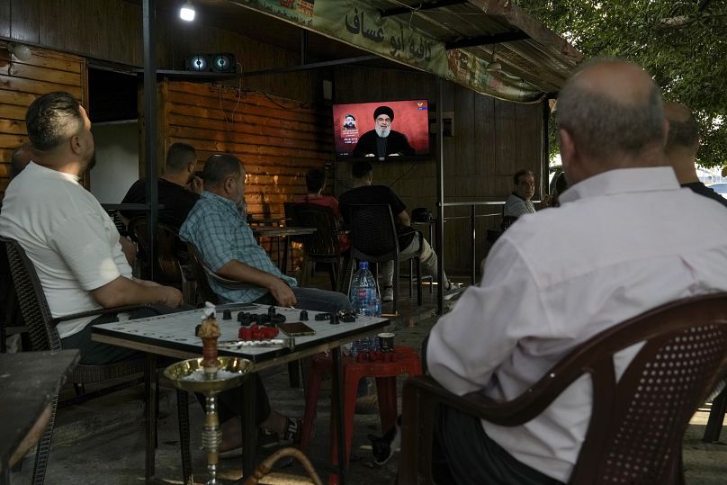 People listen to a speech by Hezbollah leader Sayyed Hassan Nasrallah in a coffee shop in Beirut, August 25, 2024