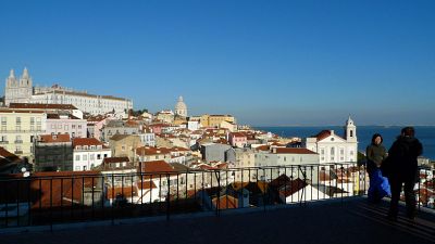 Des touristes prennent des photos sur une terrasse surplombant le quartier de l'Alfama à Lisbonne, au Portugal, le 26 décembre 2008.