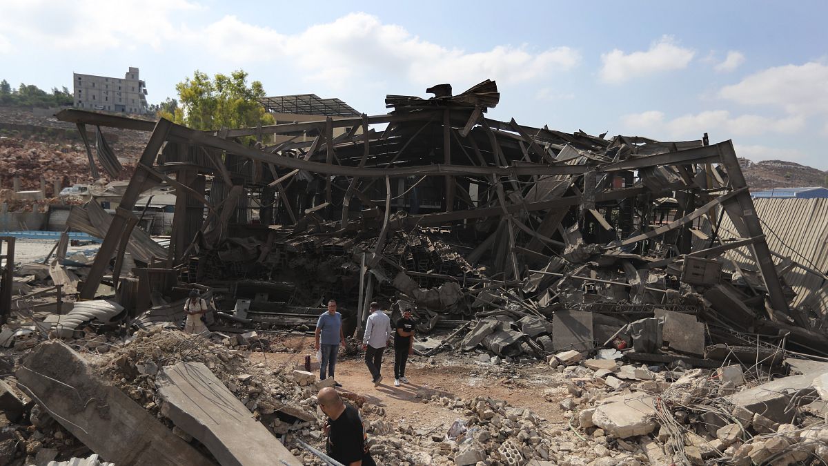 Gente caminando por una zona industrial bombardeada por Israel en Wadi al-Kfour, en el sur del Líbano