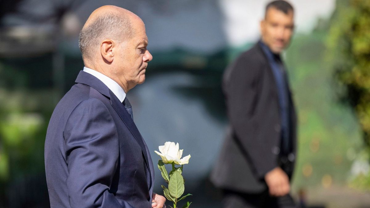 Germany Chancellor Olaf Scholz lays a flower at a church, near the scene of a knife attack, in Solingen, Germany, Monday, Aug. 26, 2024.