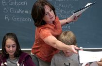 Counselor Kelley Peel, center, hands out copies of the students book they wrote and illustrated entitled "Kid's Cancer Storys" in Muskegon, June 3, 2008.