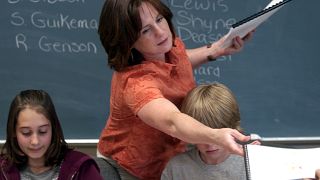 Counselor Kelley Peel, center, hands out copies of the students book they wrote and illustrated entitled "Kid's Cancer Storys" in Muskegon, June 3, 2008.