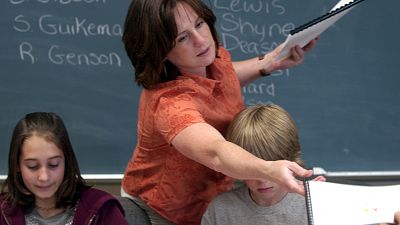 Counselor Kelley Peel, center, hands out copies of the students book they wrote and illustrated entitled "Kid's Cancer Storys" in Muskegon, June 3, 2008.