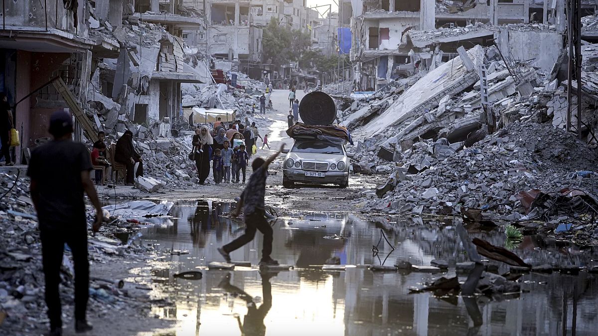 İsrail'in Gazze Şeridi'ne yönelik hava ve kara saldırısı nedeniyle yerlerinden edilen Filistinliler, güneydeki Han Yunus kasabasının sokaklarında yürüyor. (Arşiv fotoğraf)