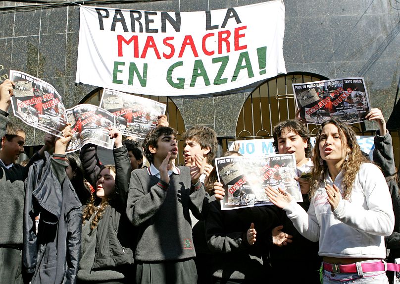 أعضاء من الجالية الفلسطينية في تشيلي يشاركون في مظاهرة ضد الهجوم الإسرائيلي على غزة، أمام الكاتدرائية الأرثوذكسية في سانتياغو، تشيلي، يوم الاثنين 7 أغسطس/آب 2006. كتب على اللا