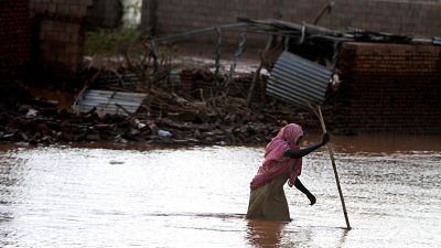 امرأة سودانية تشق طريقها عبر مياه الفيضانات في الخرطوم، السودان، الثلاثاء 6 أغسطس 2013. أدت الفيضانات التي ضربت مناطق مختلفة في السودان هذا الأسبوع إلى تدمير مئات المنازل ووفا