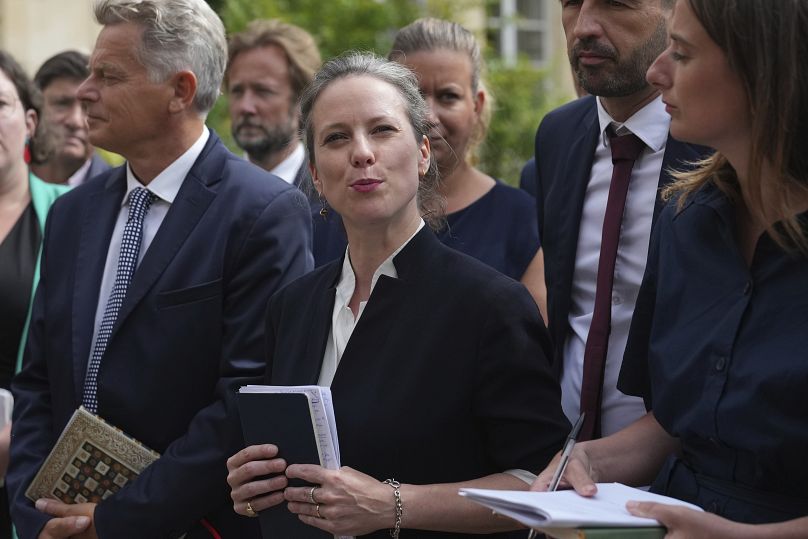 Lucie Castets, center, the New Popular Front coalition's choice for prime minister, speaks at the Elysee Palace after a meeting with French President Emmanuel Macron, Friday, 