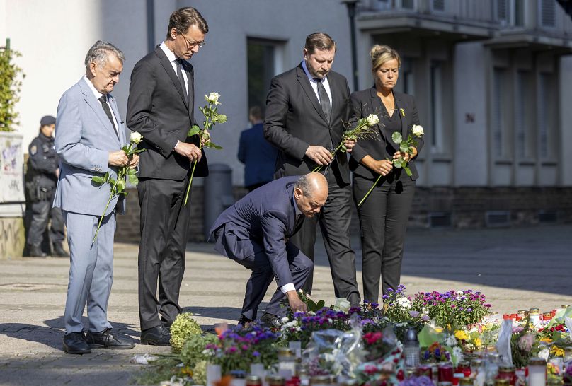 German Chancellor Olaf Scholz lays flowers near the scene of a knife attack in Solingen.