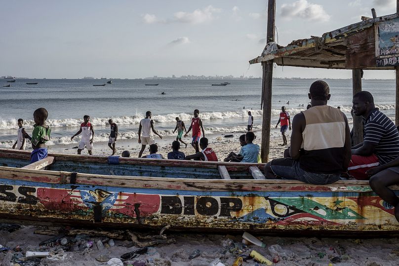 Des personnes se prélassent sur la plage de Thiaroye-Sur-Mer, au Sénégal, d'où partent régulièrement des embarcations en destination des îles Canaries, vendredi 23 août 2024