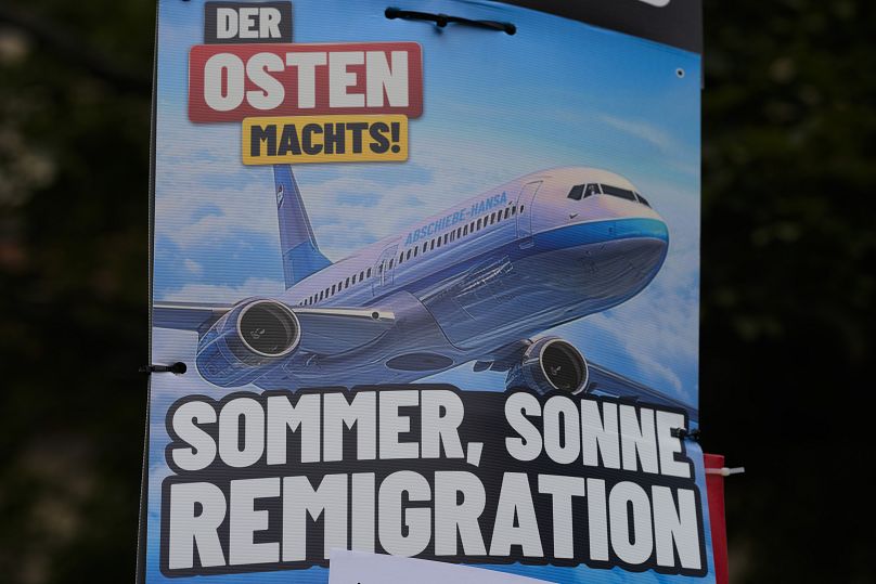 An AfD election campaign posters showing the slogan "summer, sun, remigration," are displayed in Erfurt.