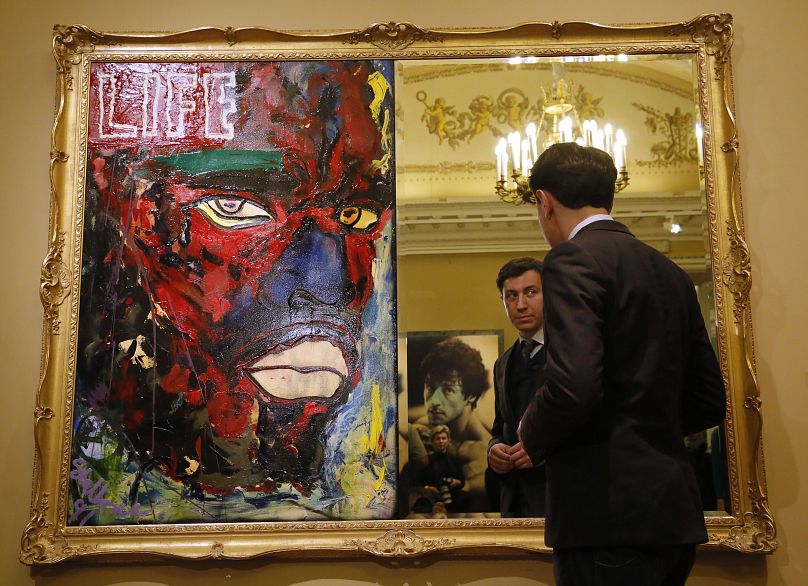 A visitor is reflected in the piece of art "Backlash", half of of which is a mirror, at an art exhibition in Russia in 2013.